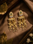 Gold kundan chandbali earrings with pearl tassels resting on bronze silk fabric with jasmine flowers