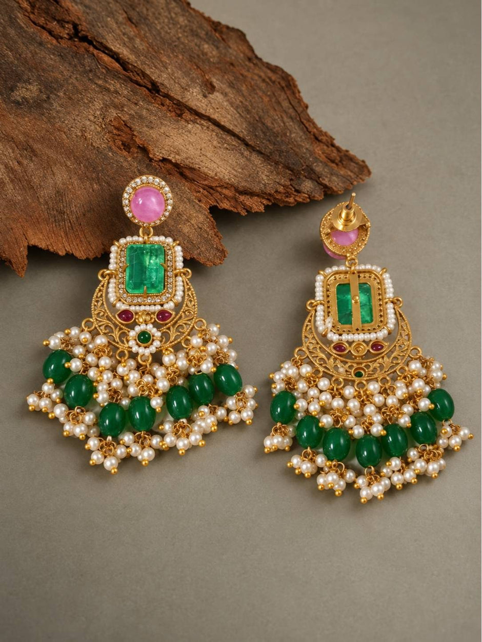Front and back view of gold-plated emerald chandbali earrings showing filigree body, green bead cascades, pearl clusters, and push-back stud fitting