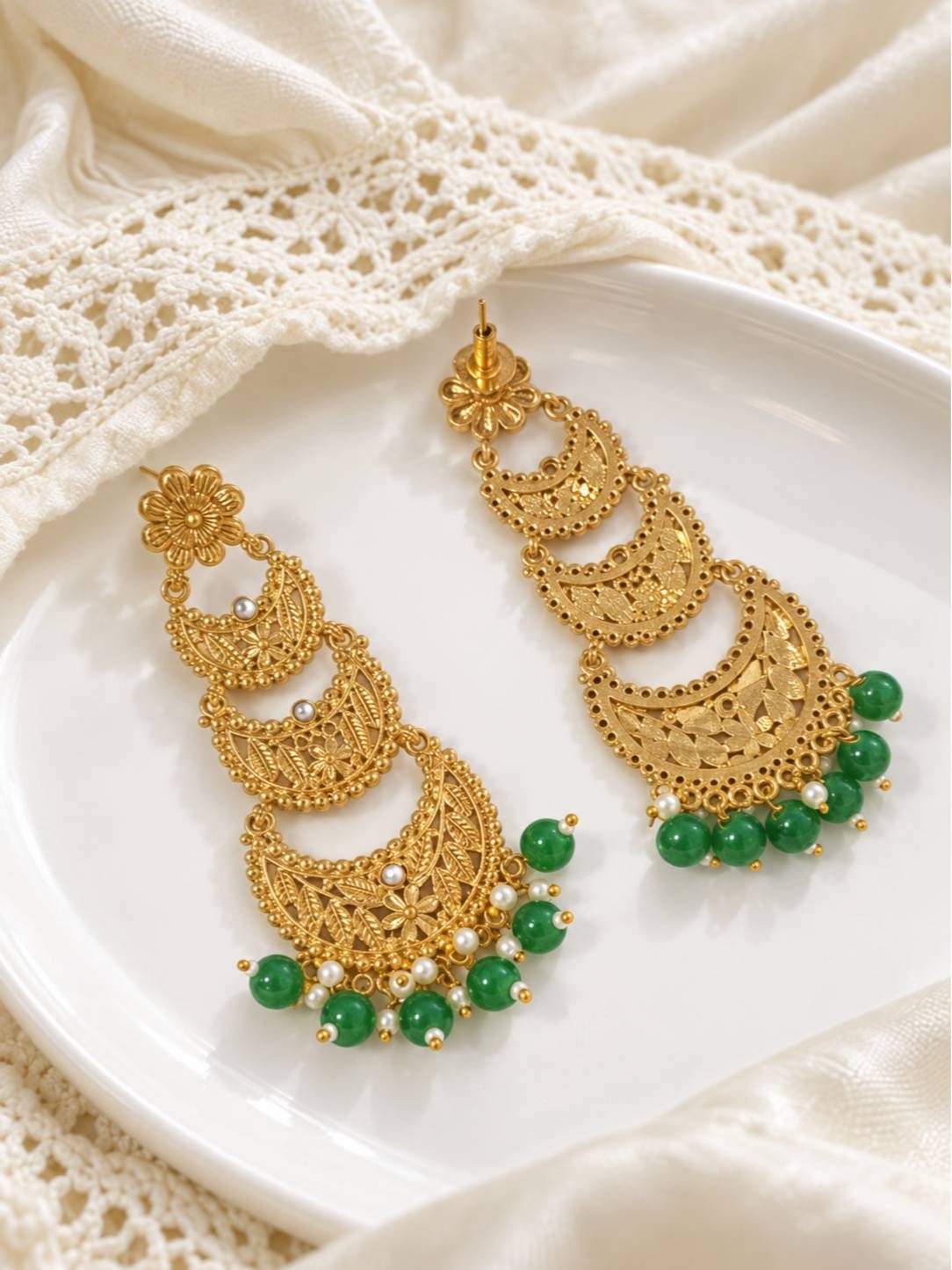 Side-by-side view of gold chandbali earrings on white plate showing front and back detail