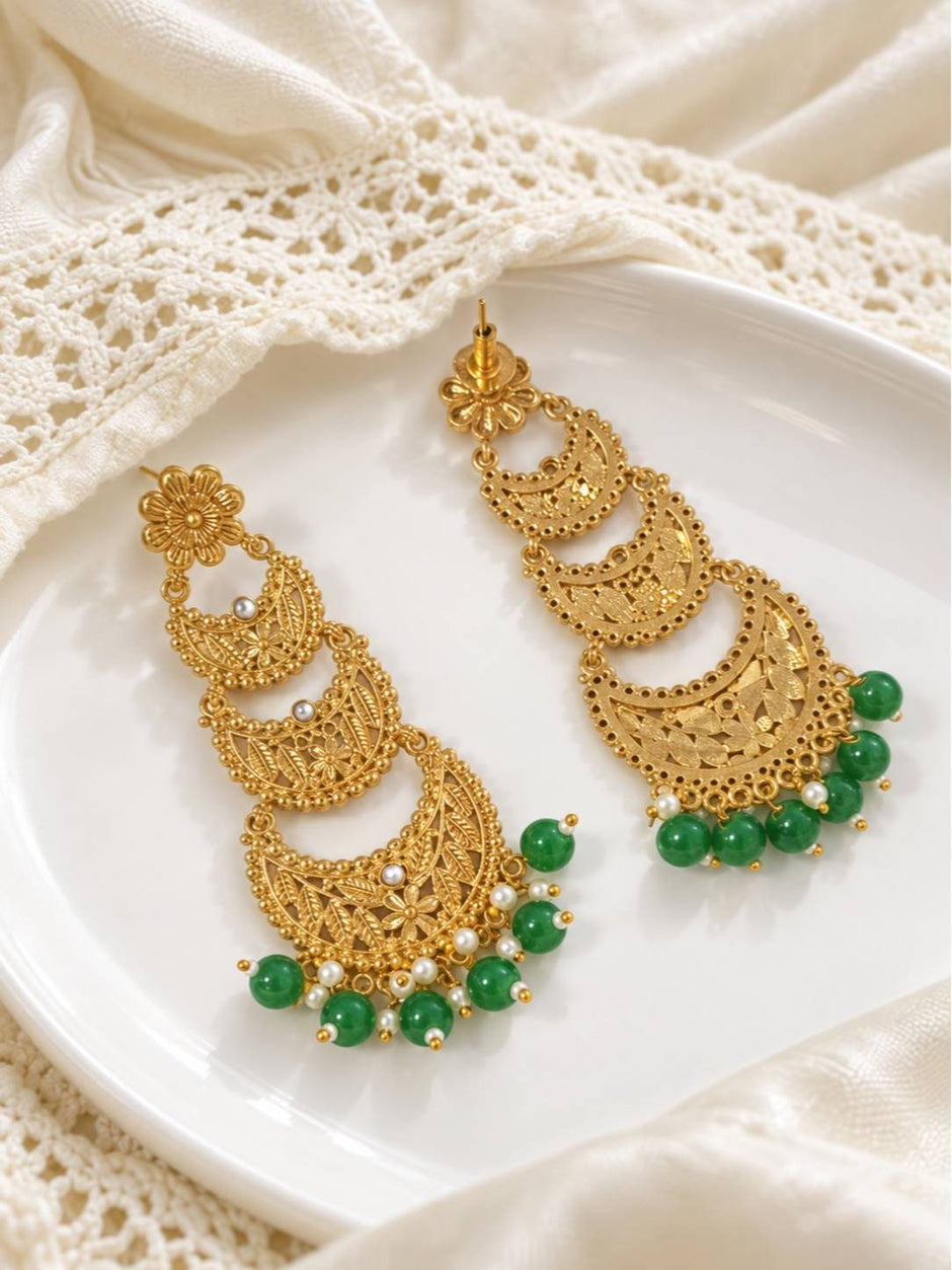 Side-by-side view of gold chandbali earrings on white plate showing front and back detail