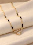 Close-up of CZ stone mangalsutra pendant with marquise accents resting on cream fabric