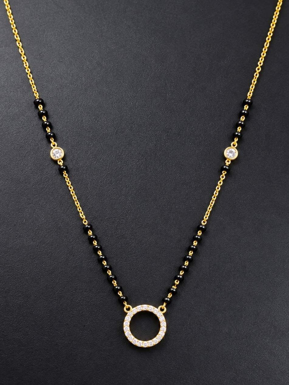 Close-up of gold-plated mangalsutra showing CZ circle pendant and bezel-set accent stones on chain