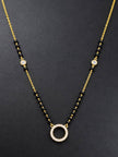 Close-up of gold-plated mangalsutra showing CZ circle pendant and bezel-set accent stones on chain