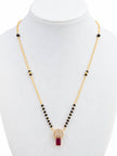 Gold-plated black bead mangalsutra with circular CZ and ruby-red pendant displayed on white jewellery bust