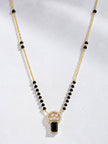 Close-up of gold-plated black bead mangalsutra with CZ circular pendant on grey background