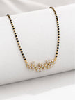 Close-up of three CZ flower pendant motifs on gold-plated mangalsutra draped over a white roll