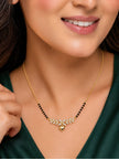 Woman wearing gold-plated CZ mangalsutra with heart pendant over a dark green outfit