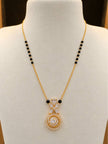Gold-plated CZ mangalsutra with black beads displayed on a white jewellery bust