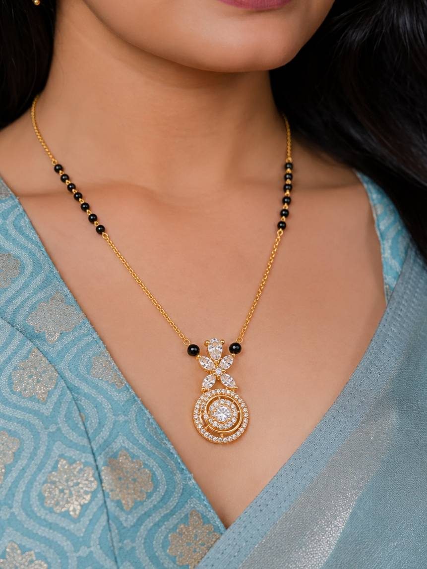 Woman wearing gold-plated CZ mangalsutra over a light blue embroidered saree