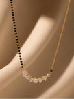 Close-up of curved CZ bar pendant with pear and round stones on draped fabric background