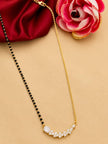 Mangalsutra with CZ bar pendant laid flat beside a pink rose on peach background