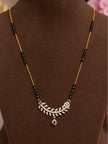 Gold-plated CZ leaf mangalsutra displayed on a brown jewellery bust showing black bead chain and teardrop drop