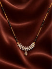 Close-up flat-lay of the curved wheat-leaf CZ pendant and black bead chain on deep red satin fabric