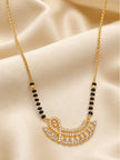 Close-up of gold-plated mangalsutra showing black beads and cubic zirconia fan pendant on satin