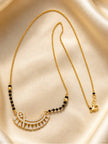 Full-length view of gold-plated CZ mangalsutra laid flat on cream satin showing lobster clasp