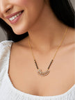 Woman wearing gold-plated CZ mangalsutra necklace with black beads over a white top