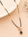 Black bead mangalsutra with white CZ marquise and black teardrop pendant on a cream stand with flowers