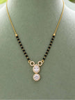 Gold-plated CZ mangalsutra with black beads and pear round halo pendant on green display bust