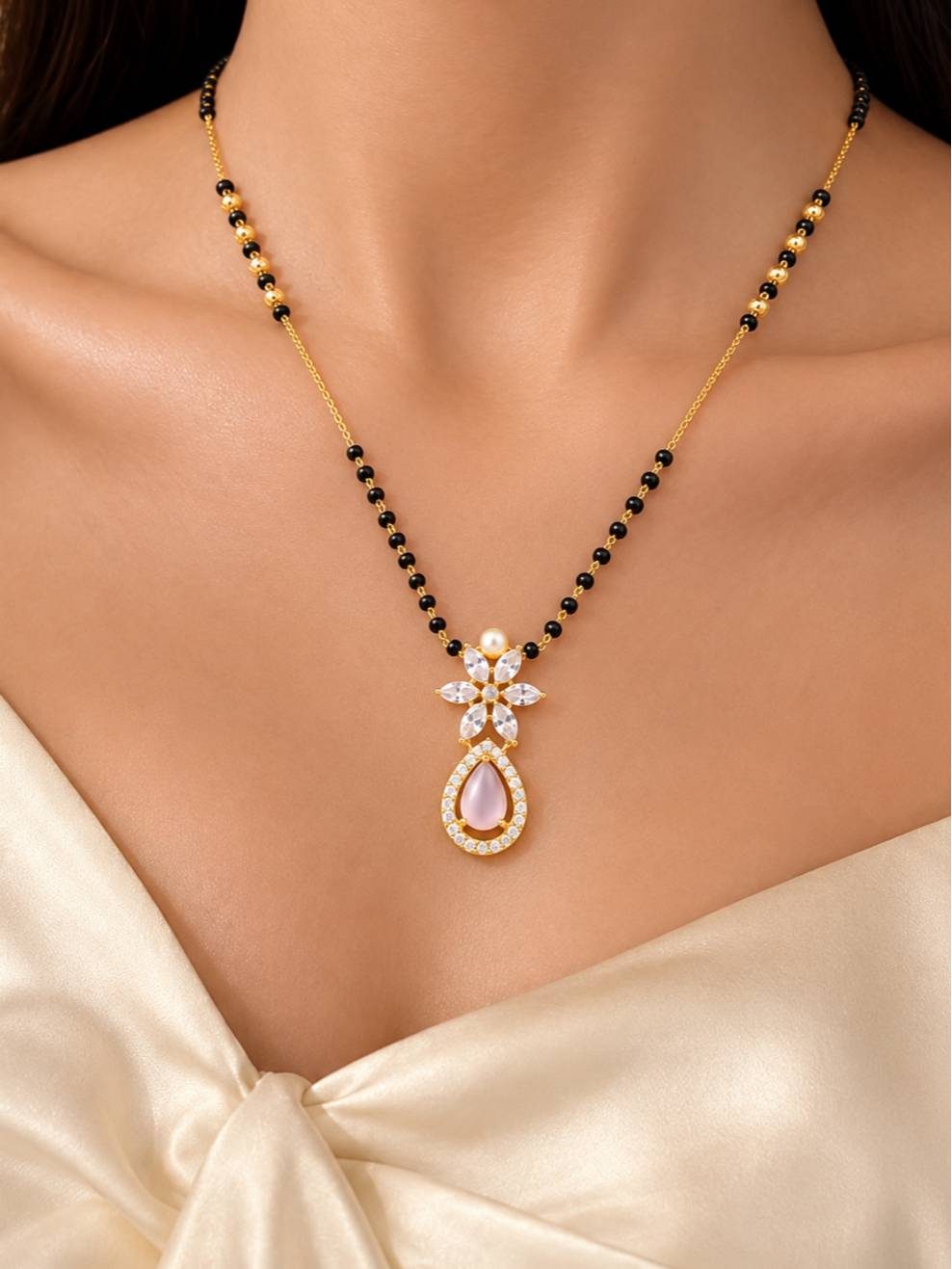 Model wearing gold-plated mangalsutra over a white top, showing how the black bead chain and CZ pendant sits at the neckline