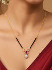 Gold-plated CZ mangalsutra worn on a model's neck paired with a deep red saree, showing pendant drape at chest level