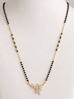 Gold-plated CZ leaf mangalsutra with black and gold beads displayed on a white jewellery bust