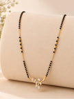 Full-length view of gold-plated CZ leaf mangalsutra draped on a beige display cushion
