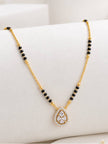 Close-up of gold-plated mangalsutra with cubic zirconia teardrop pendant on white surface