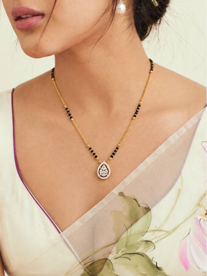 Woman wearing gold-plated CZ mangalsutra over a printed silk saree blouse