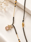 Close-up of CZ pendant and lobster clasp of gold-plated black bead mangalsutra on white surface