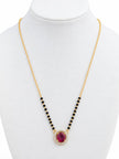 Gold-plated mangalsutra with ruby CZ halo pendant and black bead chain on white jewellery bust