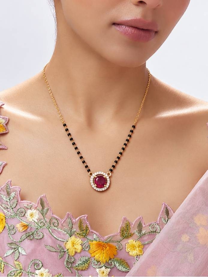 Model wearing gold-plated ruby CZ mangalsutra over embroidered pink saree blouse