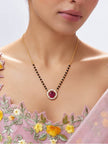 Model wearing gold-plated ruby CZ mangalsutra over embroidered pink saree blouse
