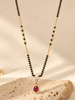 Ruby CZ and white CZ floral mangalsutra pendant on a textured stone surface in natural light