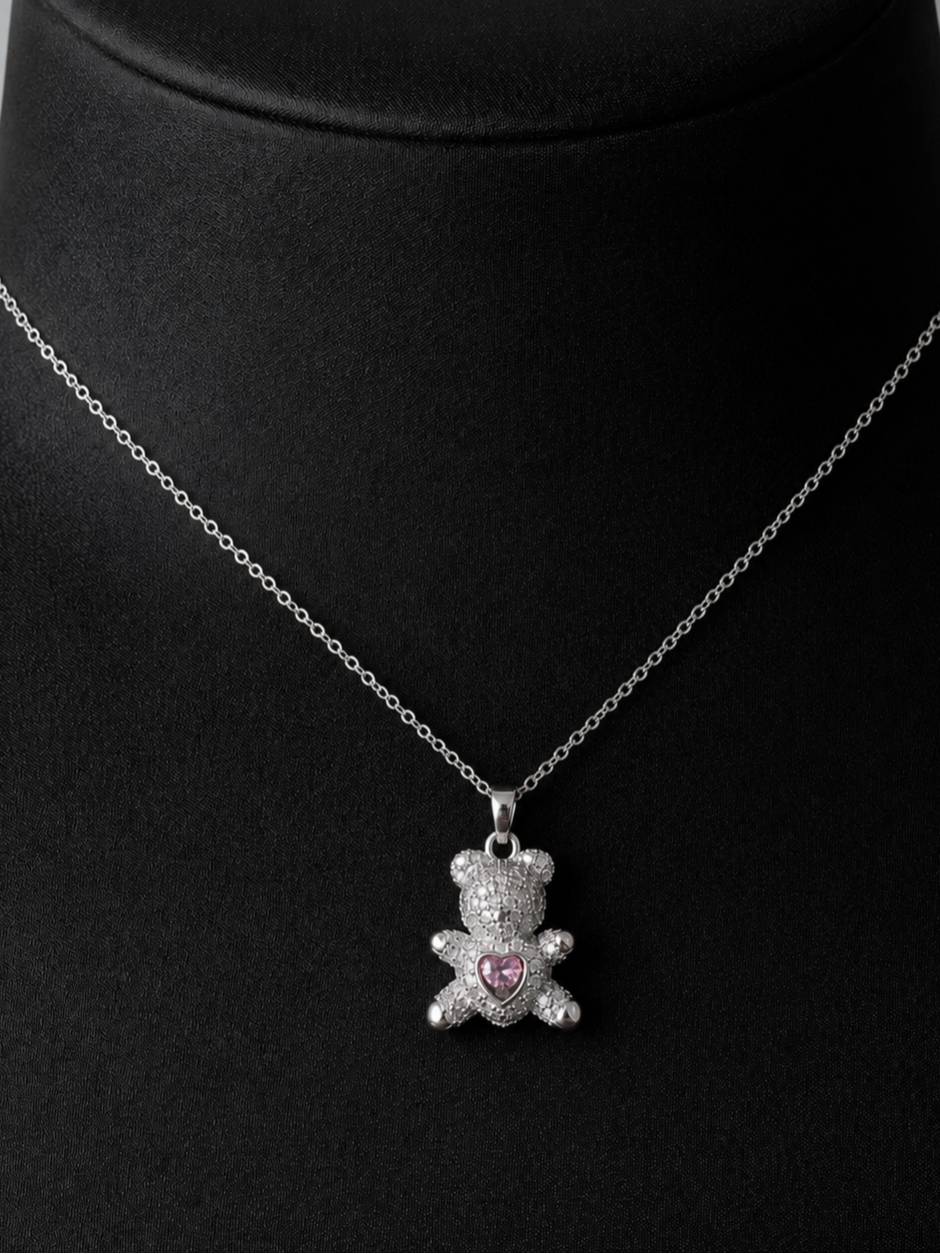 Silver-tone pavé CZ teddy bear pendant necklace displayed on a black jewellery bust