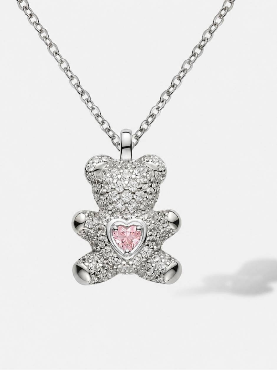 Close-up of silver CZ teddy bear pendant with pink heart cubic zirconia on white background