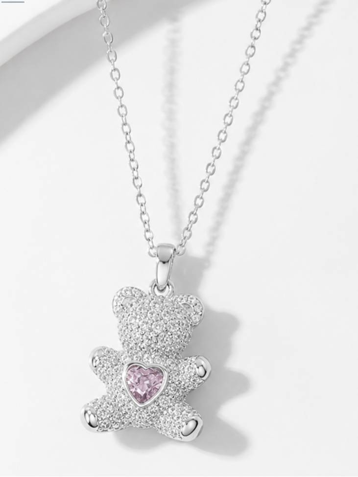 Silver CZ teddy bear necklace laid flat on white surface showing full chain and pendant detail