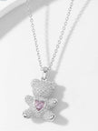 Silver CZ teddy bear necklace laid flat on white surface showing full chain and pendant detail