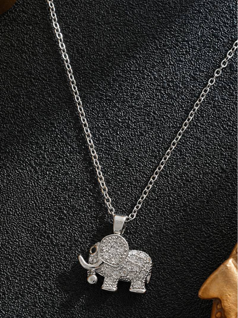 Silver-tone CZ elephant pendant necklace displayed flat on black textured surface