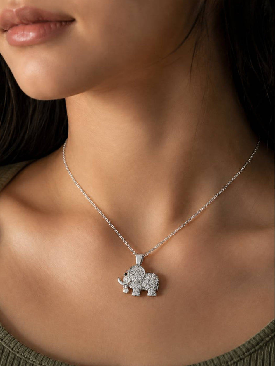 Woman wearing silver cubic zirconia elephant pendant necklace on bare neckline
