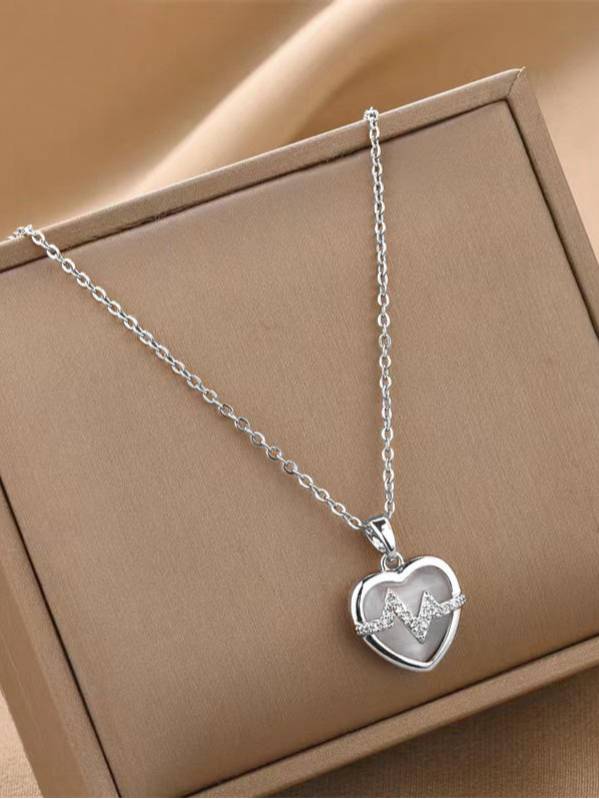 Silver heart heartbeat pendant necklace displayed in an open beige jewellery box