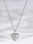 Full length silver cable chain with heart heartbeat pendant hanging centred on white background