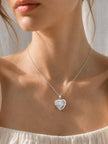Heart pendant necklace with dark grey mother-of-pearl inlay variant on white textured background