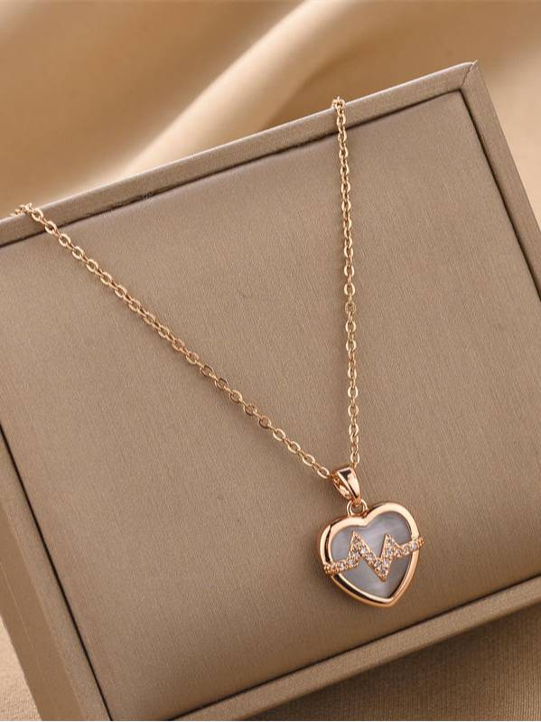 Rose gold heart pendant necklace with CZ heartbeat motif displayed in a beige jewellery box