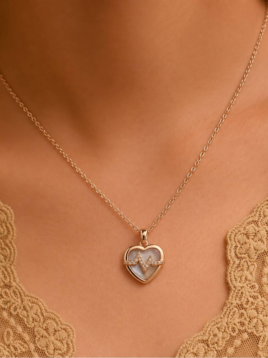 Rose gold heartbeat heart necklace worn on a woman's neckline over a lace top