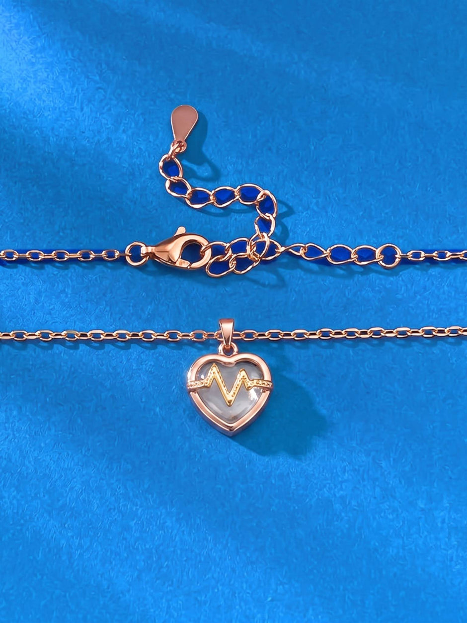 Flat lay of rose gold heart pendant and cable chain showing lobster clasp and extender detail