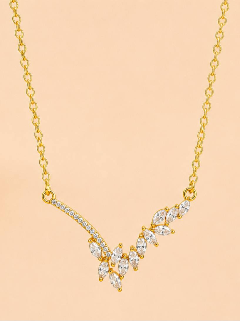 Front view of gold-plated CZ V-bar necklace showing marquise cluster and pavé curved bar against peach background