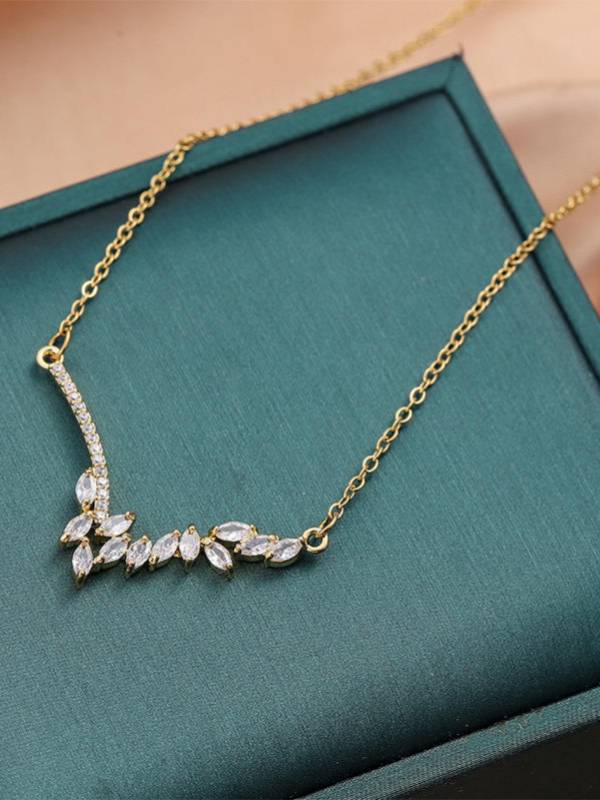 Gold-plated marquise CZ necklace laid on a teal jewellery box showing full pendant detail