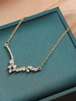 Gold-plated marquise CZ necklace laid on a teal jewellery box showing full pendant detail