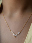 Model wearing gold-plated CZ marquise necklace at collarbone level styled with a yellow outfit
