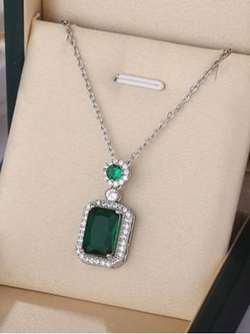 Emerald green CZ pendant necklace resting inside a beige jewellery gift box